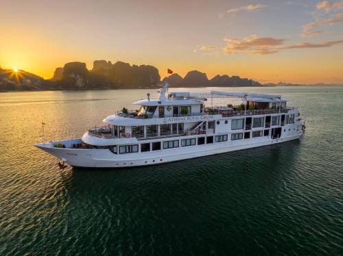 a cruise ship in the water at sunset at Athena Royal Cruise - Luxury in Halong Bay in Ha Long