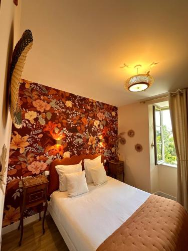 a bedroom with a large bed with a floral wall at Le Presbytère • Maison Flore in Chédigny