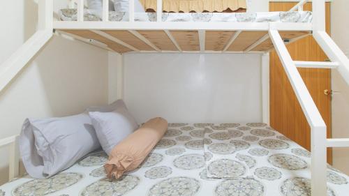 a bedroom with a bunk bed with a ladder at CM Apartelle Iloilo International Airport by RedDoorz in Cabatuan