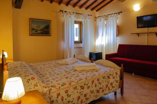 a bedroom with a bed and a red couch at Agriturismo Villa Guarnaschelli in Scandicci