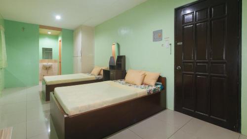 a bedroom with two beds and a bathroom at CM Apartelle Iloilo International Airport by RedDoorz in Cabatuan
