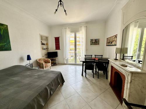une chambre avec un lit, une table et des chaises dans l'établissement 242 Cannes La Croisette - Studio au calme coté jardin, à Cannes