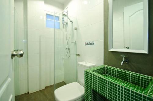 a bathroom with a shower and a toilet and a sink at DI Place in Bangkok