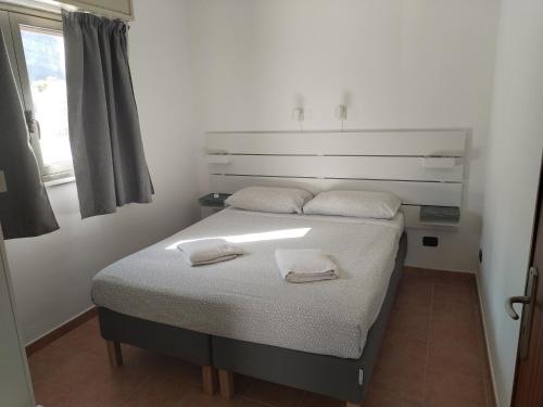 a bedroom with a bed with two towels on it at Casavacanze corallo in Isola delle Femmine