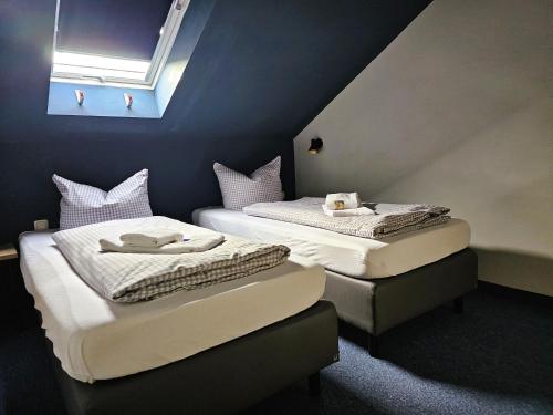 two twin beds in a room with a window at ARRIVEL Pension Pliening - bisher Novitel in Pliening