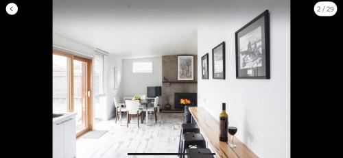 a living room with a fireplace and a table with a bottle of wine at Sandy point hideaway in Sandy Point