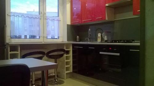 a kitchen with black cabinets and a table and chairs at Apartament Sandra in Kielce