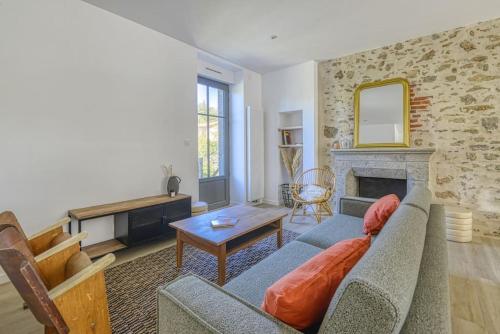 ein Wohnzimmer mit Couch und Kamin in der Unterkunft Gîte de l'Etoile, maison rénovée à 18min du PuyduFou in Pouzauges