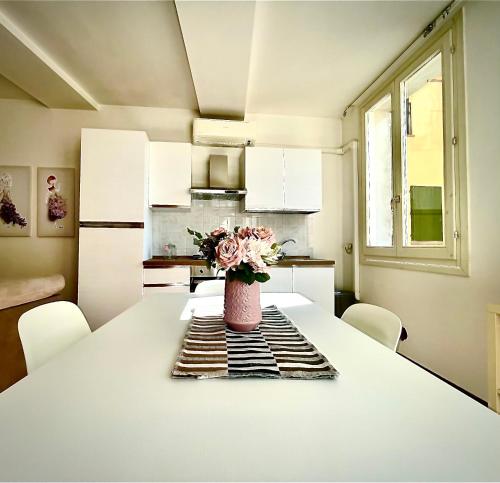 a kitchen with a table with a vase of flowers on it at Canalchiaro55 in Modena