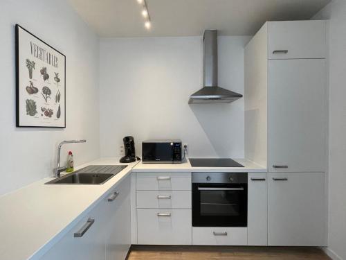a white kitchen with a sink and a refrigerator at Belfort Shortstay in Ghent
