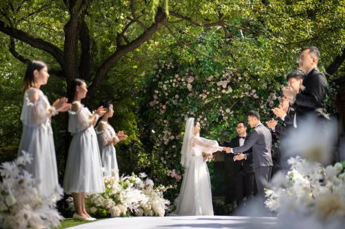 a bride and groom shaking hands during their wedding ceremony at HUALUXE Yangjiang City Center in Yangjiang