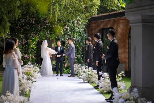 a bride and groom exchanged vows at their wedding ceremony at HUALUXE Yangjiang City Center in Yangjiang