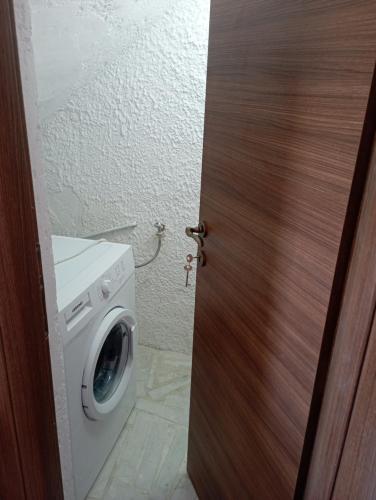 a door open to a washing machine in a bathroom at Akrogiali Rooms & Studios in Drymonas