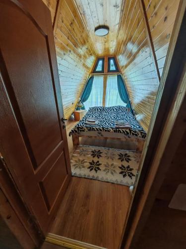 an attic room with a bed and a window at A Frame Alpin in Vatra Dornei