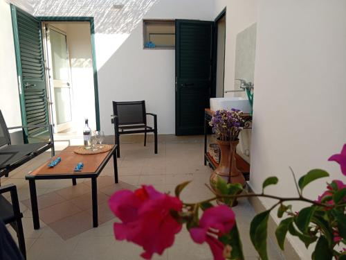 a living room with a table and chairs and flowers at Dimora Lilium in Otranto