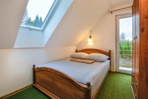 a bed in a room with a window at Panskiemisie Domki Całoroczne sauna jacuzzi in Wetlina