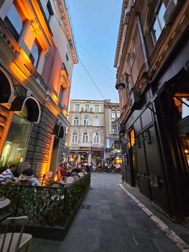 a city street with people sitting at tables and buildings at Leopold Chillout Hostel in Sarajevo