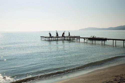 a group of people on a pier in the water at Domes Miramare, a Luxury Collection Resort, Corfu - Adults Only in Moraitika