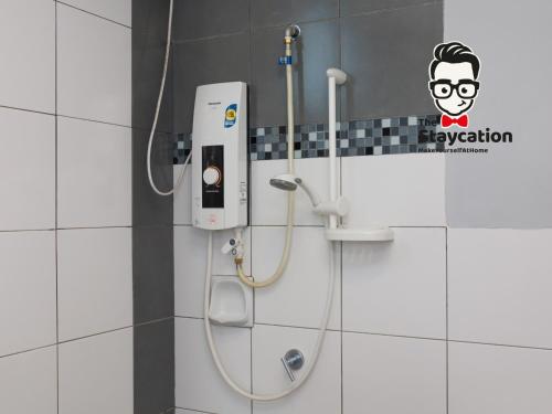 Una ducha en un baño con un cartel en la pared. en Staycation Homestay 54 Skyvilla Condo near MJC, en Kuching