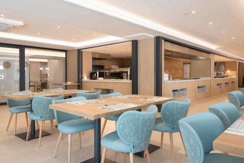 a dining room with a table and blue chairs at Hotel Palia Tropico Playa in Palmanova