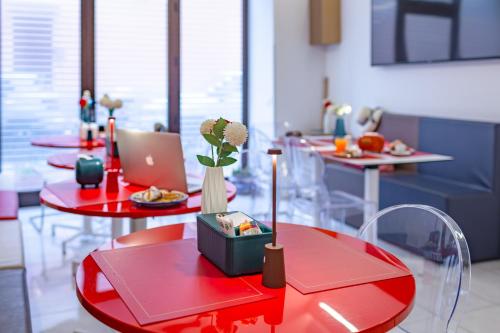 a room with red tables with plates of food at Fazio Rooms in Sciacca