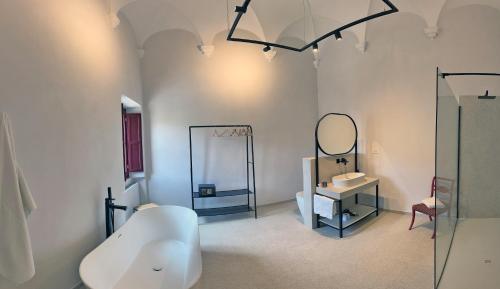 a bathroom with a tub and a sink and a mirror at Abbazia Santa Maria del Bosco in Contessa Entellina