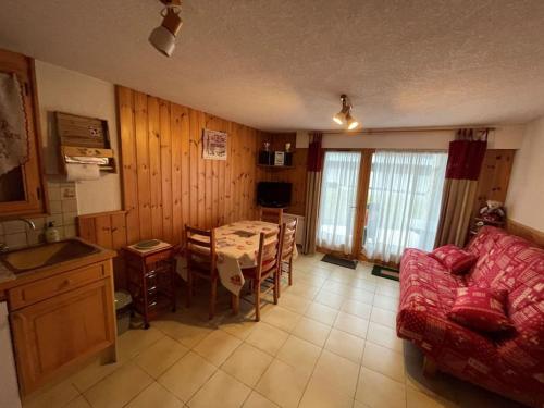 un salon avec une table et un canapé rouge dans l'établissement Studio au coeur de Samoens, à Samoëns