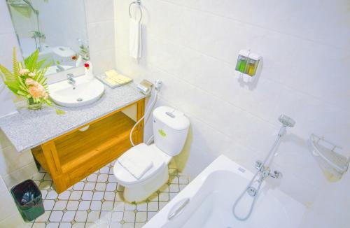 a white bathroom with a toilet and a sink at Mandalay Lodge Hotel in Mandalay