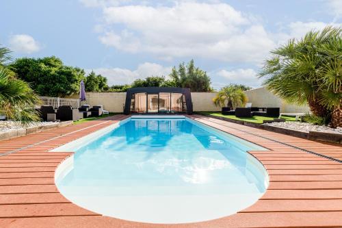 - une piscine dans un jardin avec un kiosque dans l'établissement La Maison Paradis - Piscine privée et chauffée, à Luçon