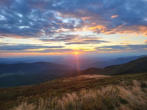 a view of a sunset from the top of a mountain at Panskiemisie Domki Całoroczne sauna jacuzzi in Wetlina