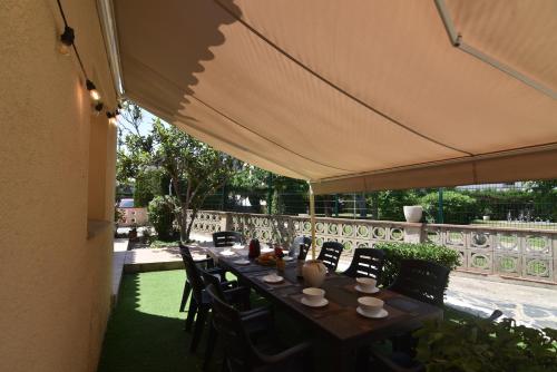 a table with chairs and an umbrella on a patio at RNET - MT - Casa Can Carles in Roses