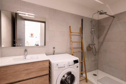 une salle de bain avec une machine à laver et un lavabo dans l'établissement Amicu - Appt climatisé vue mer, à Lumio