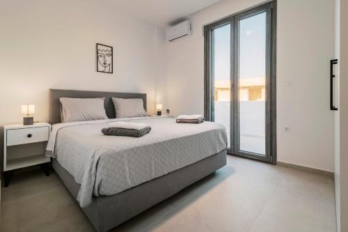 une chambre avec un grand lit et une grande fenêtre dans l'établissement Koskinou Escape Villa, à Koskinou
