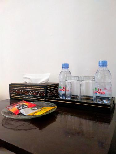 two bottles of water and glasses on a table at Wisma Samrat in Rantepao