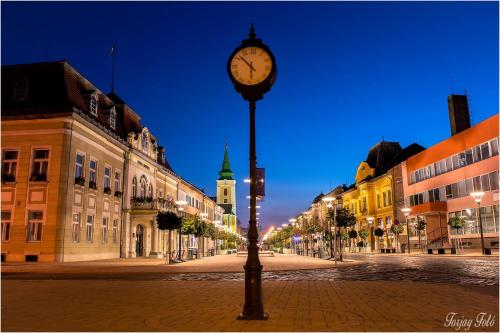 a clock on a pole on a street at night at Sztár Motel Étterem in Balassagyarmat