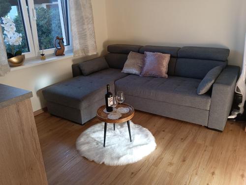 a living room with a couch and a table with wine bottles at Ferienwohnung Marlies in Lendorf