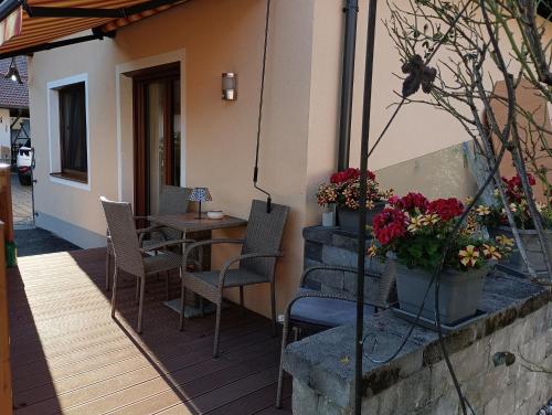 a patio with a table and chairs and flowers at Ferienwohnung Marlies in Lendorf