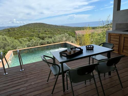 a table and chairs on a deck with a swimming pool at Résidence U Pirellu in Porto-Vecchio