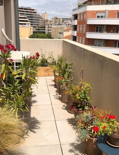 - un balcon avec une bande de plantes en pot sur un bâtiment dans l'établissement Soho So Chic Apartment with terraces, à Marseille