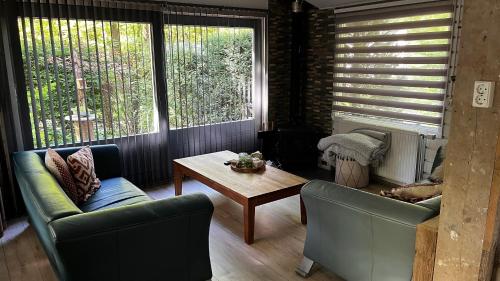 a living room with two chairs and a coffee table at Dreamwoodz - een droomchalet op de Veluwe in Laag-Soeren