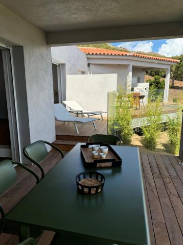a patio with a table and chairs on a deck at Résidence U Pirellu in Porto-Vecchio