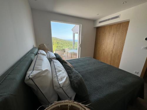 a bedroom with a bed with a large window at Résidence U Pirellu in Porto-Vecchio