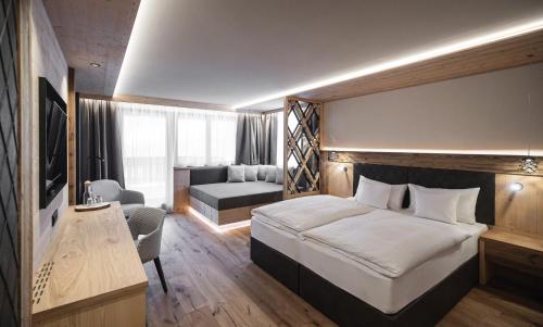 a hotel room with a bed and a desk at Hotel Alpenblick in Sesto