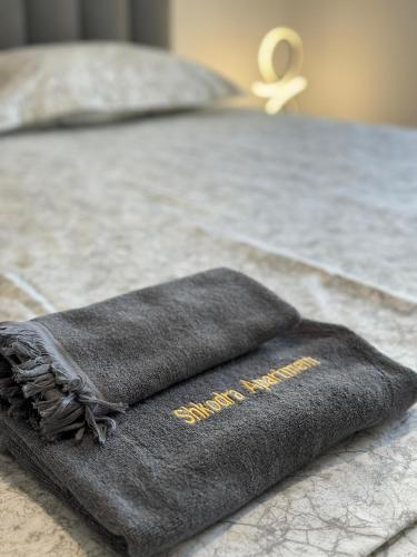 ein schwarzes Handtuch auf dem Bett in der Unterkunft Apartment in City Center in Shkodra