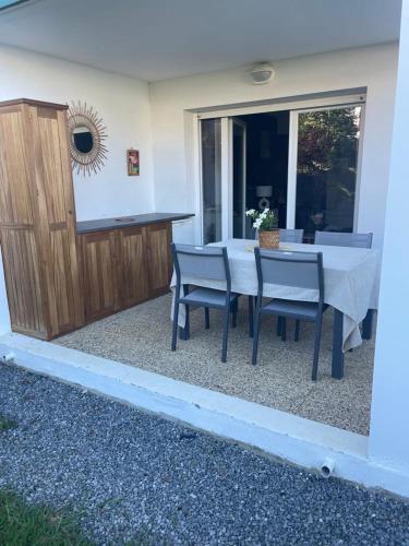une table et des chaises devant une maison dans l'établissement T2 avec jardin privatif, à Saint-Pierre-dʼIrube