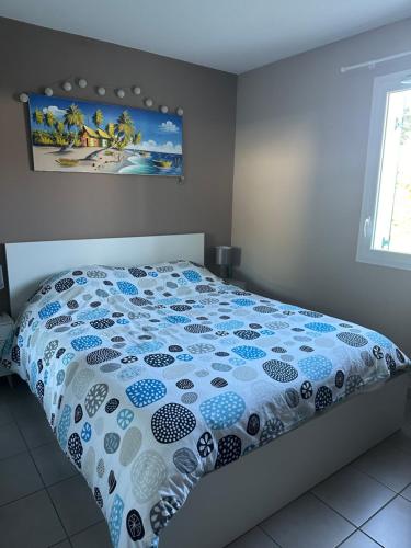 une chambre avec un lit avec une couette bleue et blanche dans l'établissement T2 avec jardin privatif, à Saint-Pierre-dʼIrube
