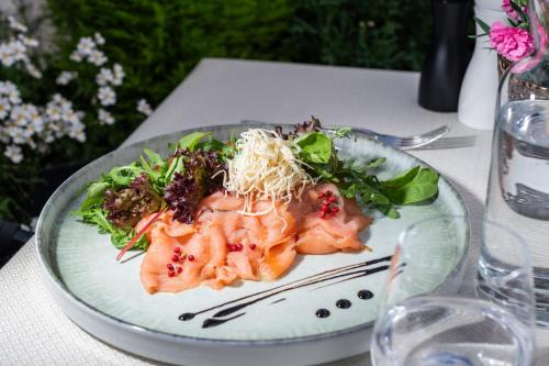 a plate of food with shrimp and greens on a table at Hotel Residence MaVie in Lagundo