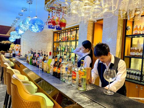 zwei Personen stehen in einer Bar in einem Restaurant in der Unterkunft Yotaka Khanom in Khanom