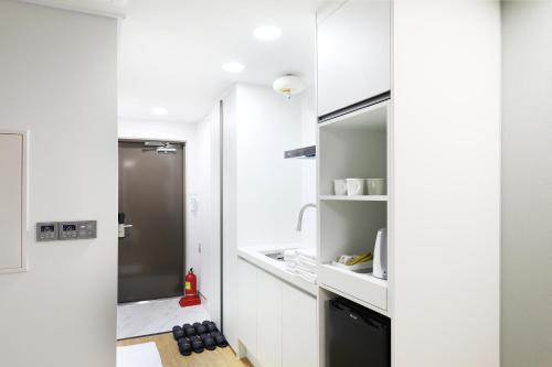 a kitchen with white walls and a door to a pantry at Mokpo Ocean Hotel in Mokpo