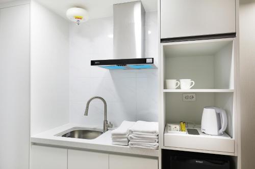 a small white kitchen with a sink and towels at Mokpo Ocean Hotel in Mokpo